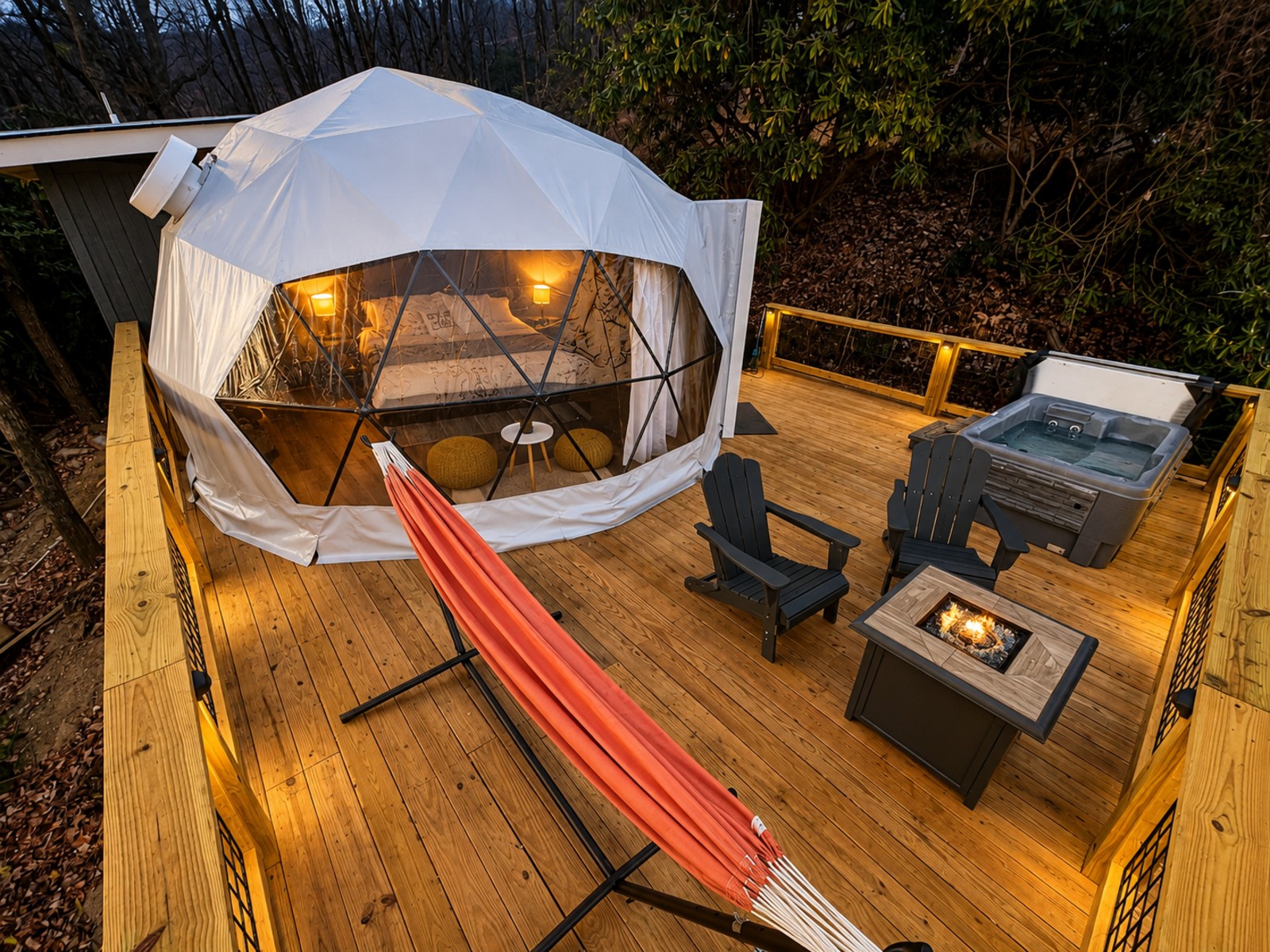 Aerial dusk view of a custom BluWolf-built deck in Watauga County, North Carolina, with a lit geodesic dome, hot tub, fire table, and cable railing